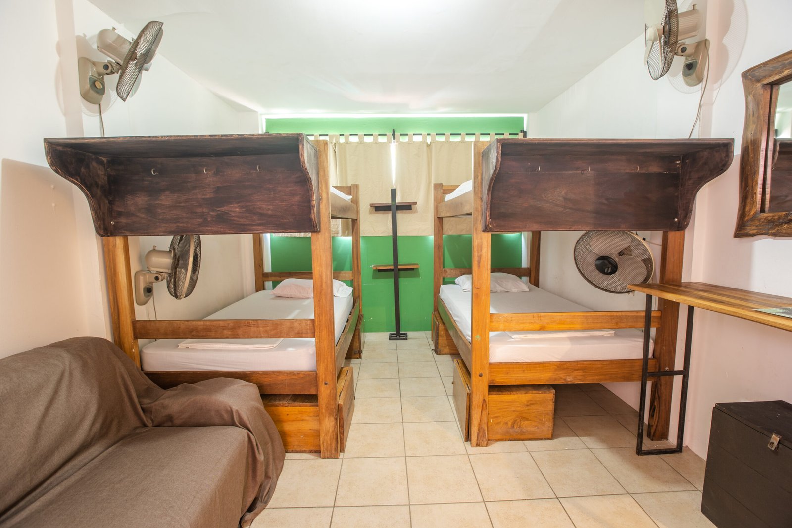 two bunk beds in dorm room, green wall