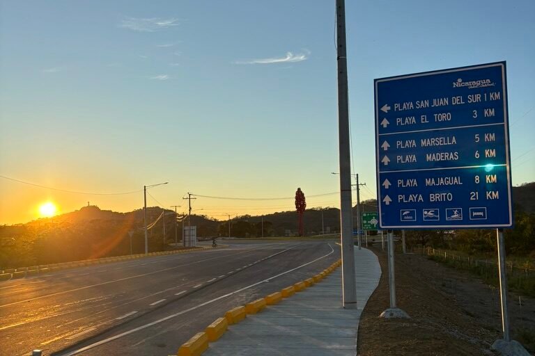 Blue road sign sunset in the back